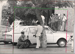 Police crouch behind cars while another group of officers negotiate with the trio