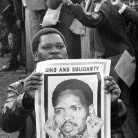 A Black Consciousness Movement member with a poster of Steve Biko